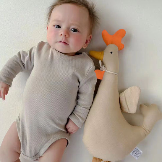 bebe couché à cÎté doudou coq