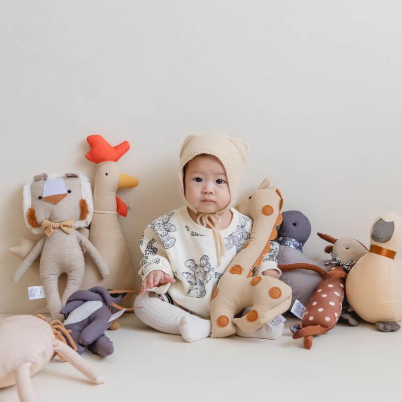 bebe qui tient doudou girafe dans bras