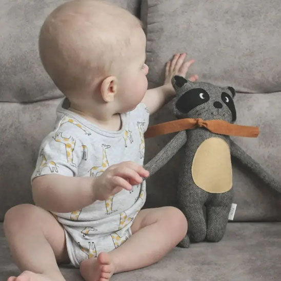 bebe qui joue avec doudou raton