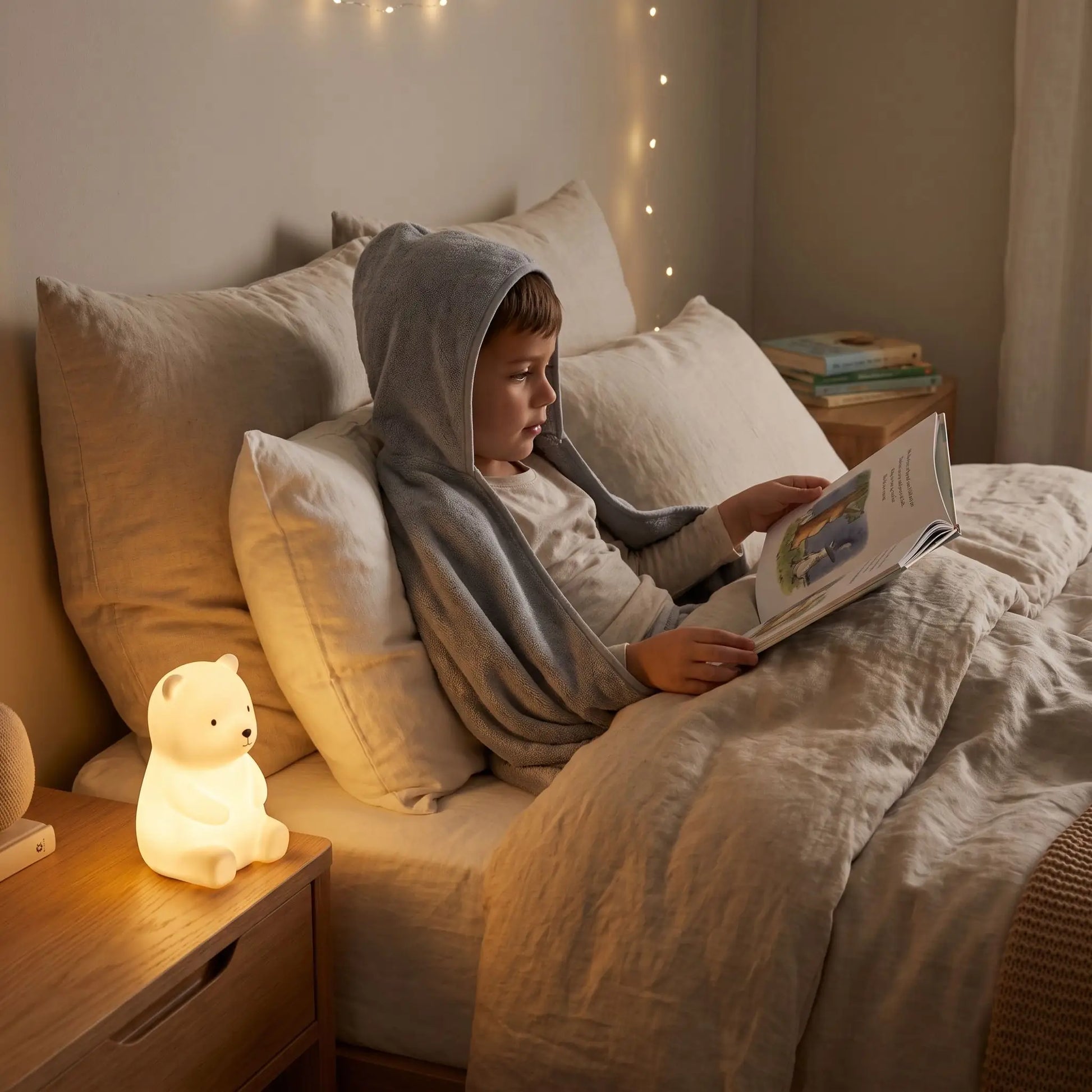 enfant dans son lit qui lit un livre avec son cocon sensoriel anti anxiété 