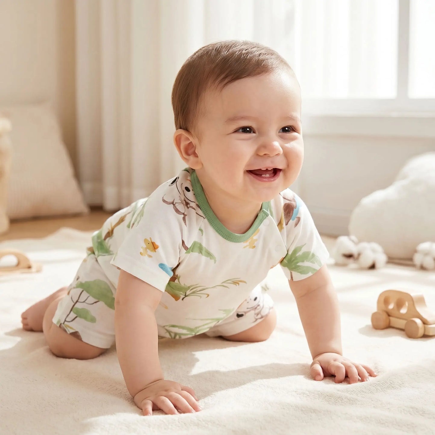 bébé souriant rampant sur un tapis habillé d'une barboteuse bébé garçon manches courtes