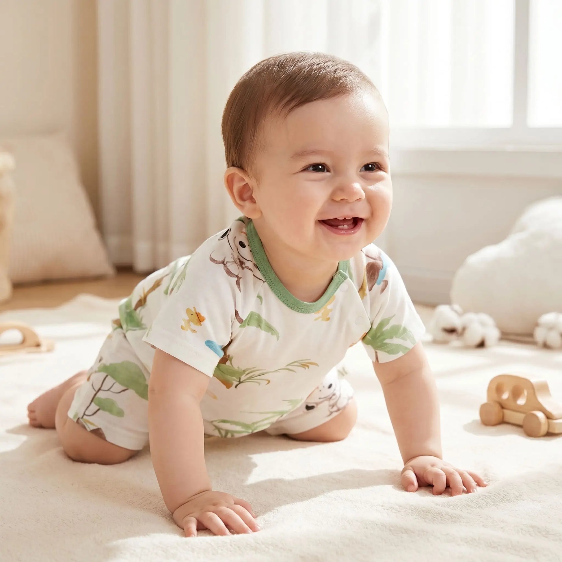 bébé souriant rampant sur un tapis habillé d'une barboteuse bébé garçon manches courtes