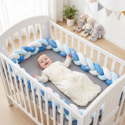 bébé qui sourit couché dans son lit sur le dos en toute sécurité, protégé par un tour de lit tressé bleu moelleux