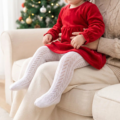 bébé en robe rouge sur les genoux de sa maman avec des collants bébé blanc en coton doux en résille