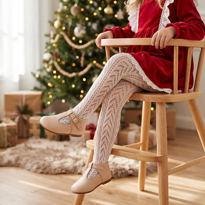 fille assise sur une chaise habillée d'une robe de noël avec collant fille beige en coton en résille