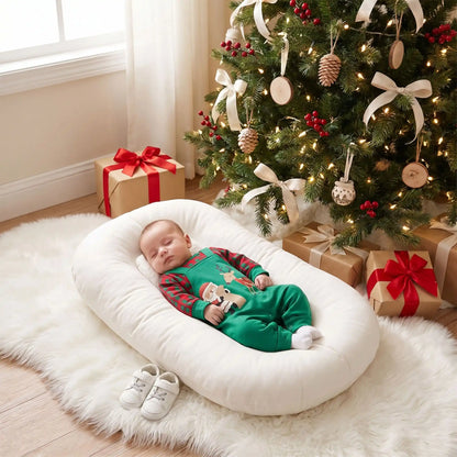 bébé qui dort dans son réducteur de lit au pied du sapin avec sa combinaison pyjama noël bébé motif écossais festif