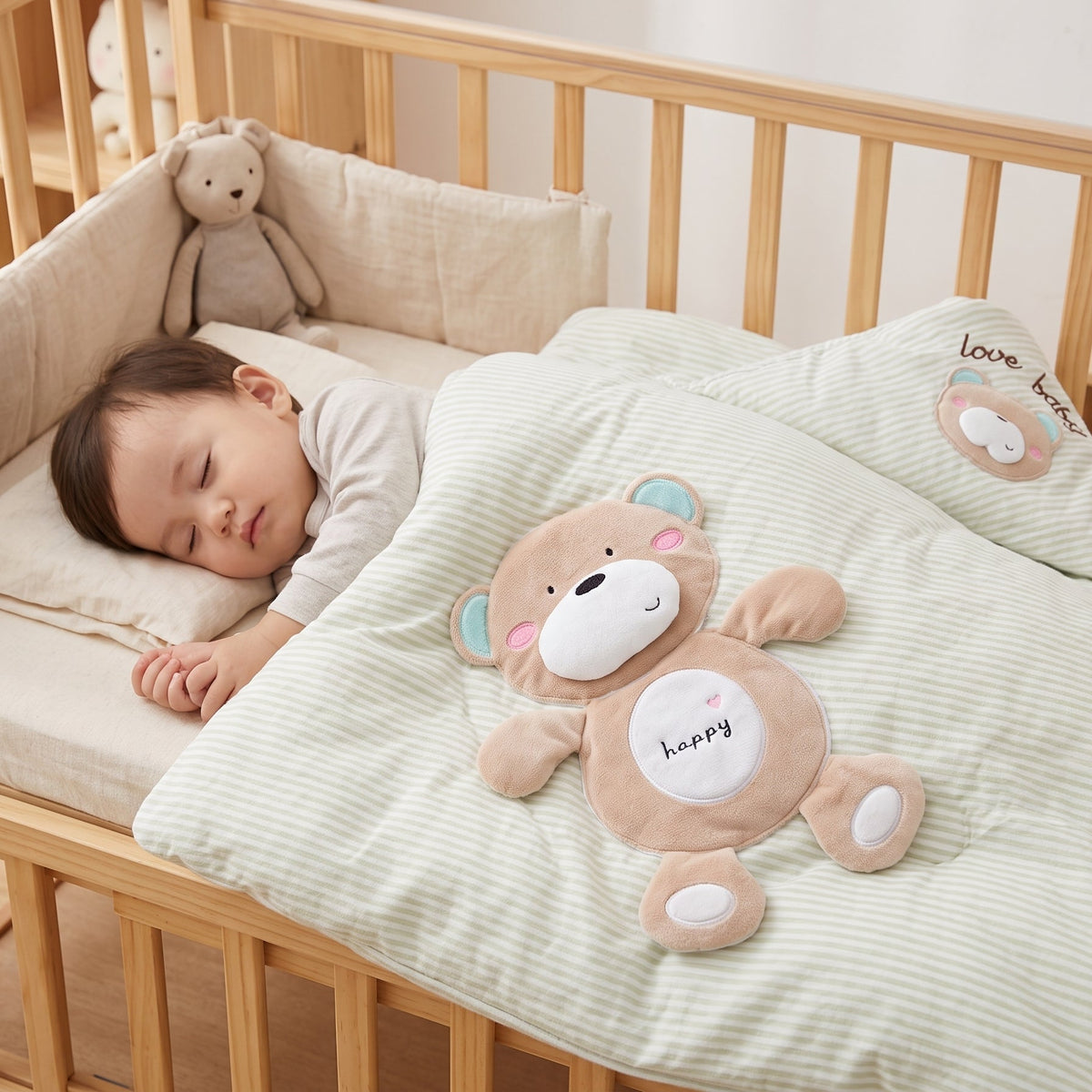 Bébé endormi dans son lit sous la couverture d'appoint dépliée issue du nid d'ange déhoussable