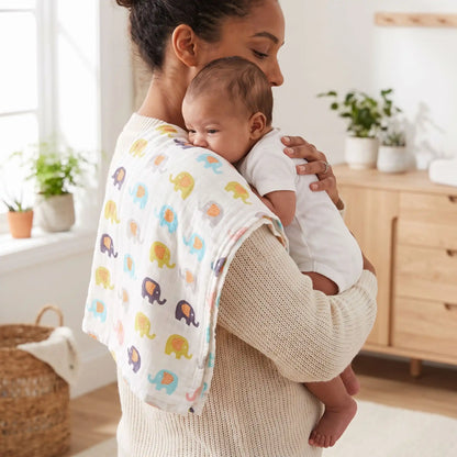 maman avec une couverture mousseline gaze de coton toutes saisons qui fait faire son rôt à son bébé