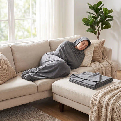 femme couchée sur le canapé avec une couverture emmaillotage pour adulte pour favoriser sommeil