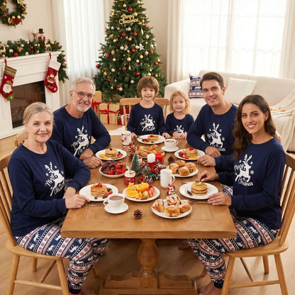 une famille rassemblée autour d'une table  à noël avec un ensemble pyjama noël famille assorti coton rennes 