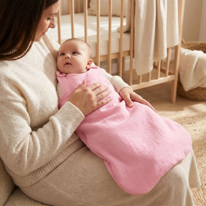 bébé fille dans sa gigoteuse sans ouatine été rose qui regarde tendrement sa maman