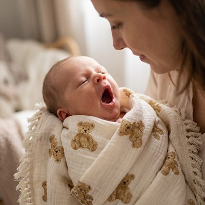 maman qui emmaillotte avec couverture bébé 