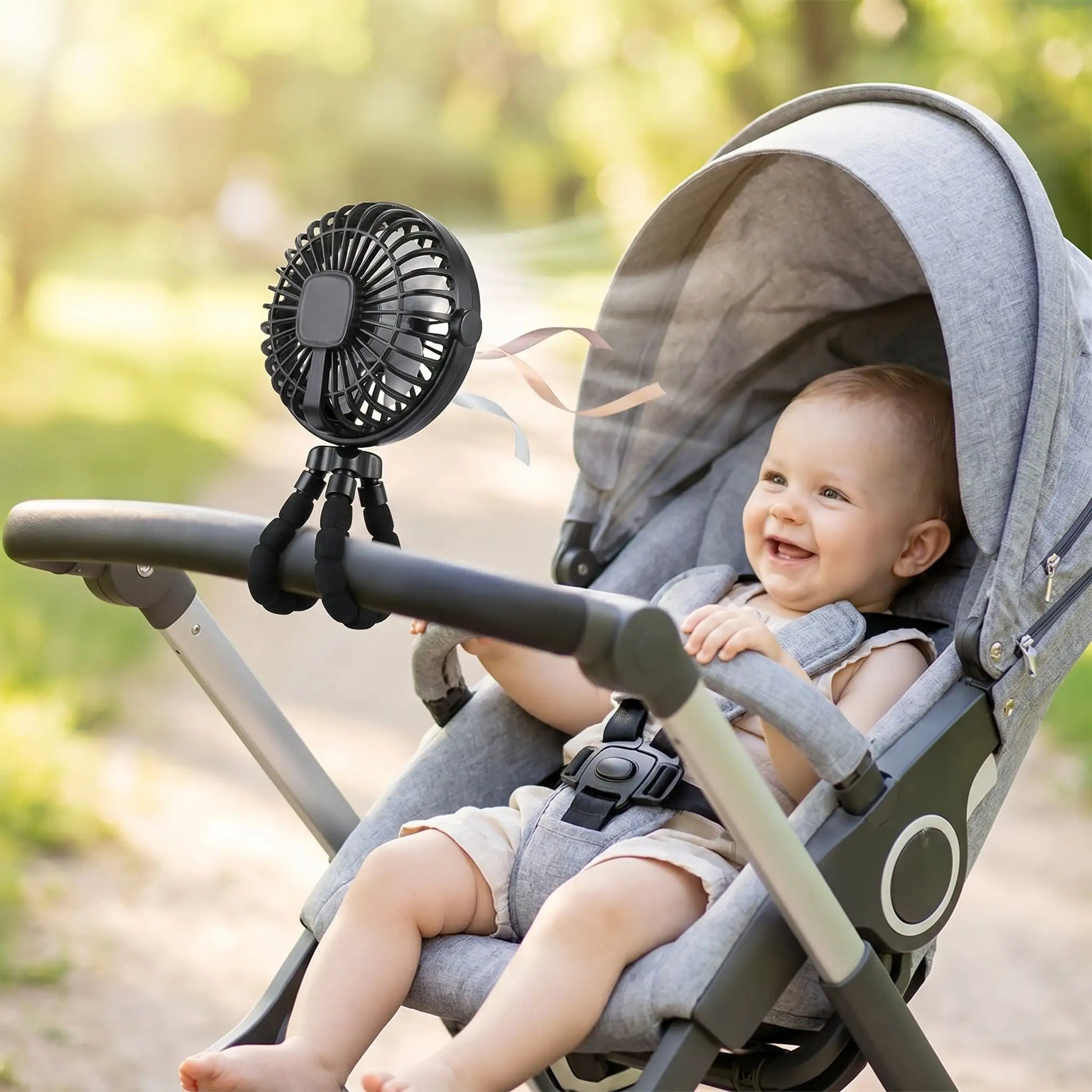 bébé qui sourit dans une poussette avec un mini ventilateur portable noir 3 vitesses fixation universelle