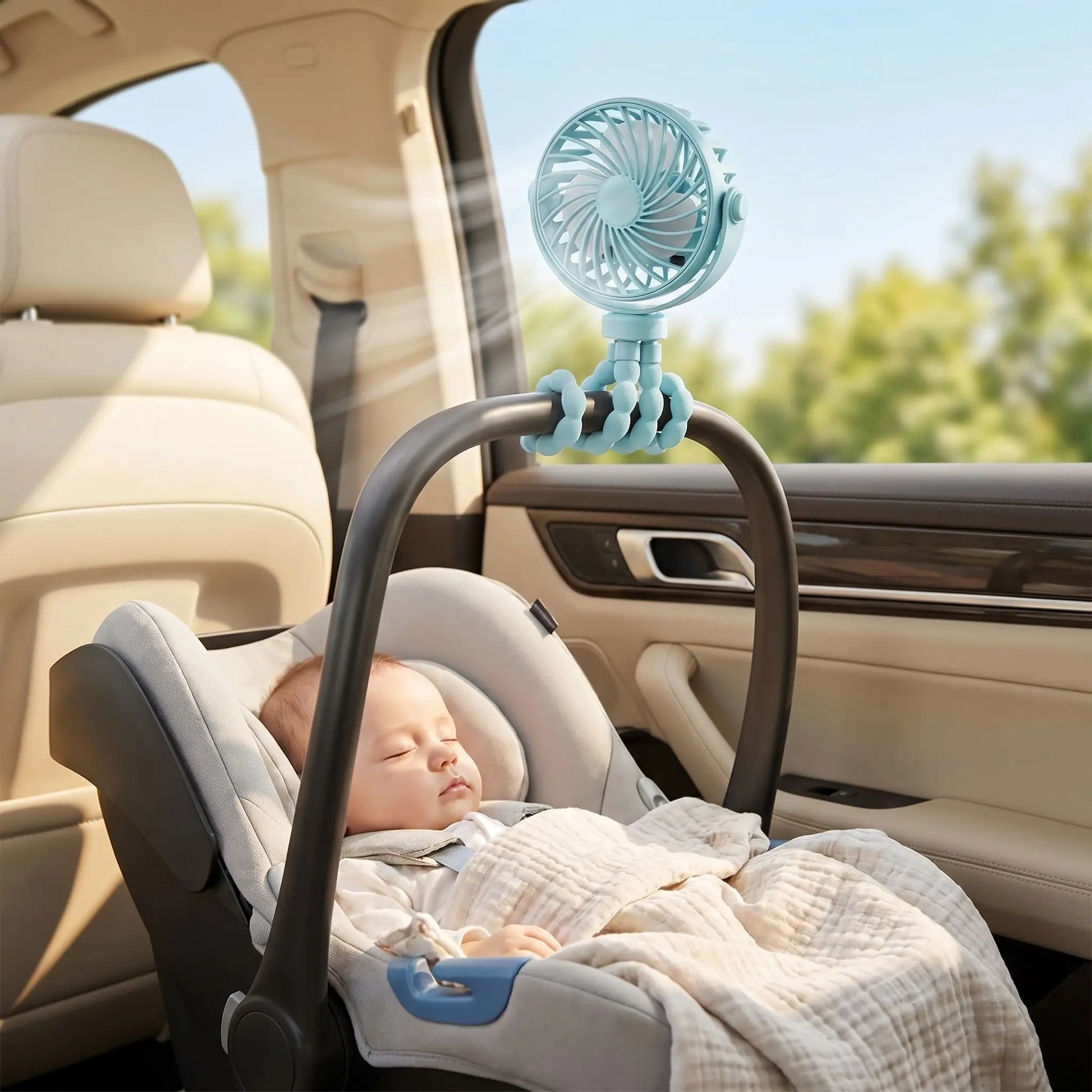 bébé qui dort dans son siège auto avec un mini ventilateur portable bleu fixé dessus