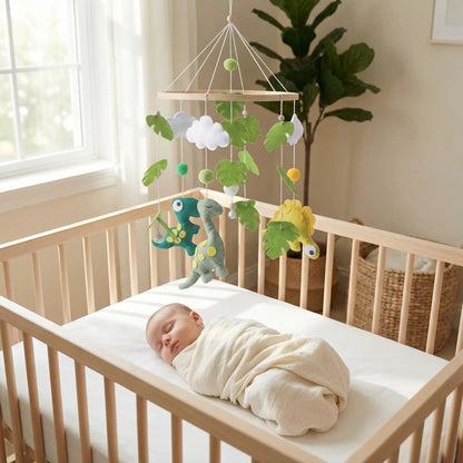 mobile bebe dinosaures accroché au lit avec un bebe qui dort
