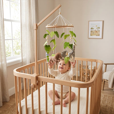 bébé qui essaie de toucher son mobile bébé safari artisanal suspendu au dessus de lui