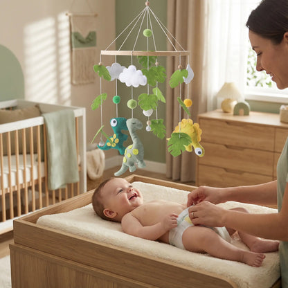 mobile pour bebe dinosaure au dessus table a langer avec un bébé qui se fait changer
