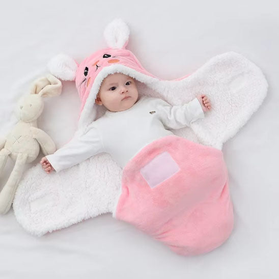 bébé dans son nid d'ange ouvert avec capuche en forme de lapin rose et sherpa à l'intérieur