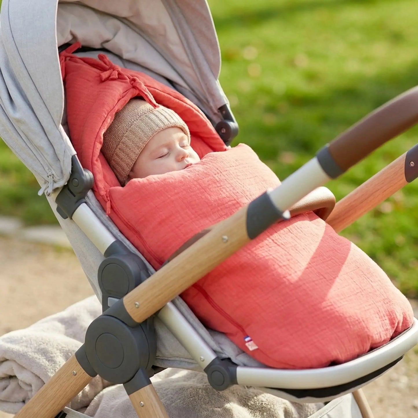 bébé qui dort dans une poussette avec un nid d'ange certifié oeko tex en coton biologique