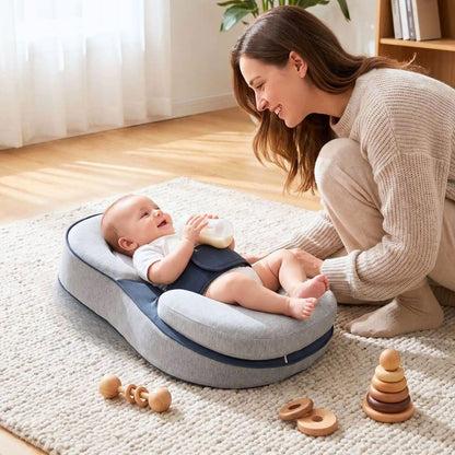 bébé qui tient son biberon dans un plan incliné bébé avec ceinture de sécurité et rebords et maman accroupit qui sourit à son bébé