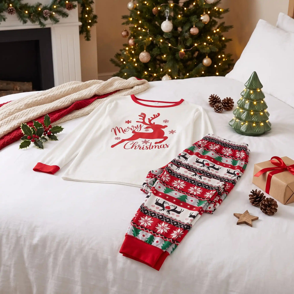 pyjama de noël famille rennes rouge et blanc posé sur un li avec des décoration de noël autour