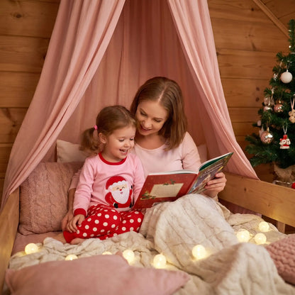 maman qui lit un conte de noel à sa petite fille habillé de son pyjama noël bebe fille père noël rose