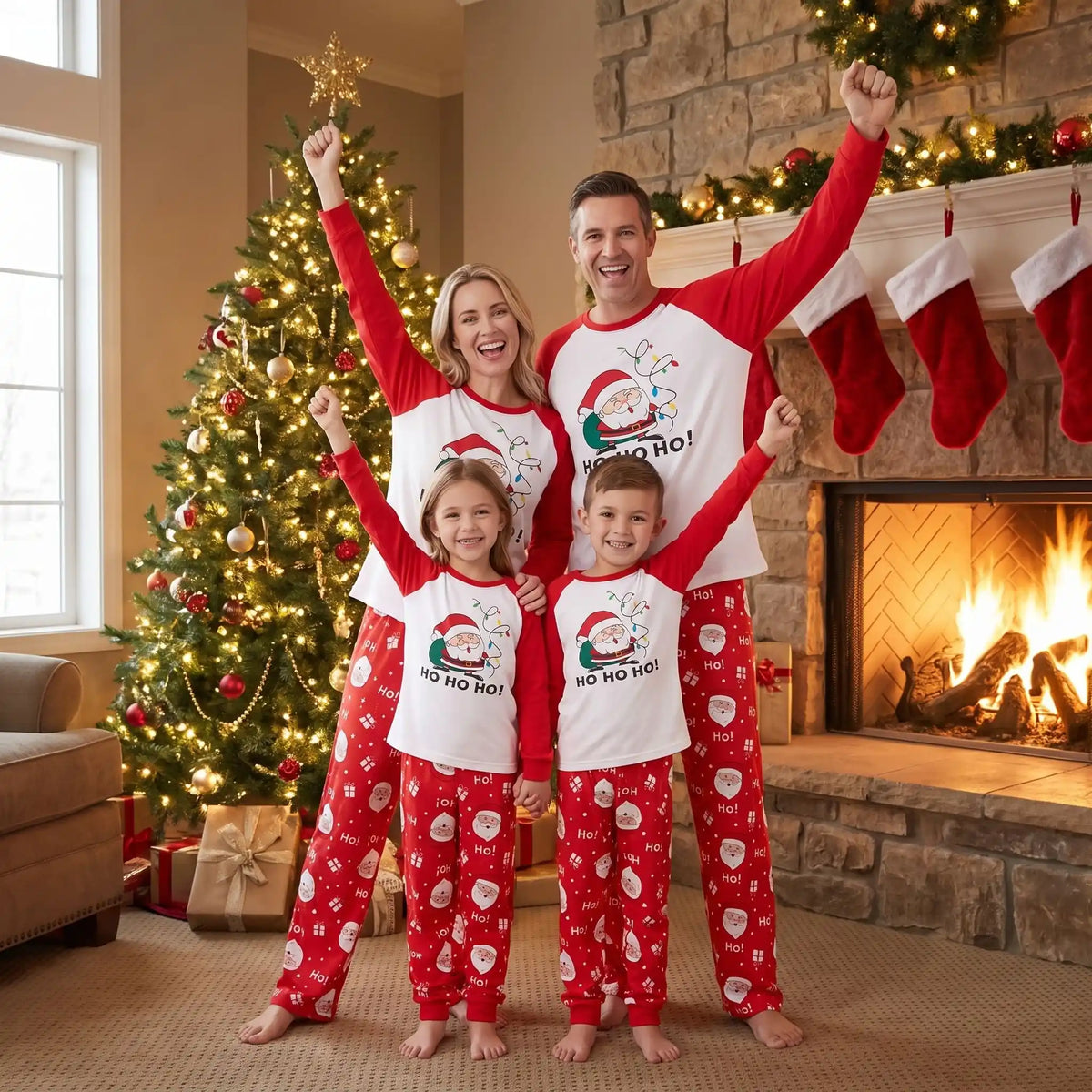 un couple et leurs deux enfants dans un même pyjama de noel pour toute la famille avec des motifs de père noel rouge et blanc
