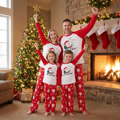 un couple et leurs deux enfants dans un même pyjama de noel pour toute la famille avec des motifs de père noel rouge et blanc