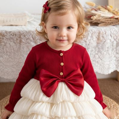 Zoom sur les finitions douces et la coupe de la robe de Noël fille en polyester rouge et blanche de 6 à 24 mois