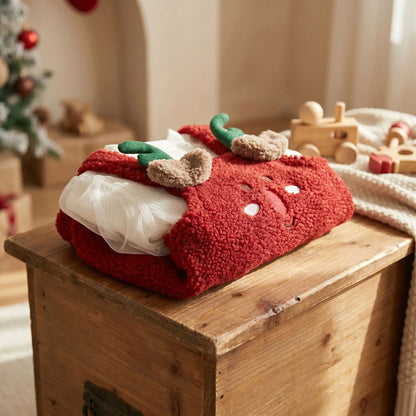 robe de noël fille rennes velours coton pliée sur un coffre à jouets en bois