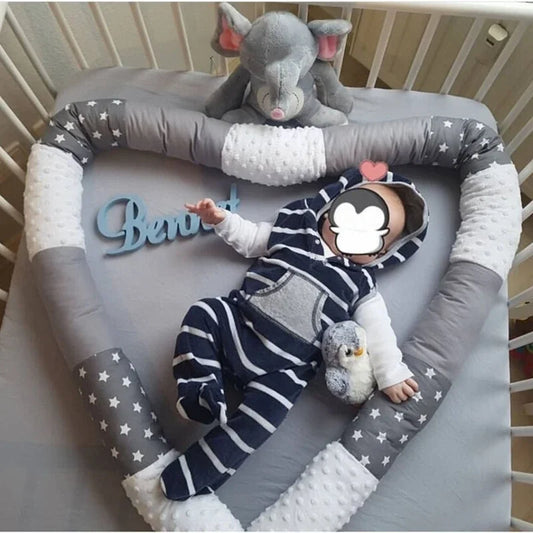 bebe entouré d'un tour de lit bebe gris patchwork