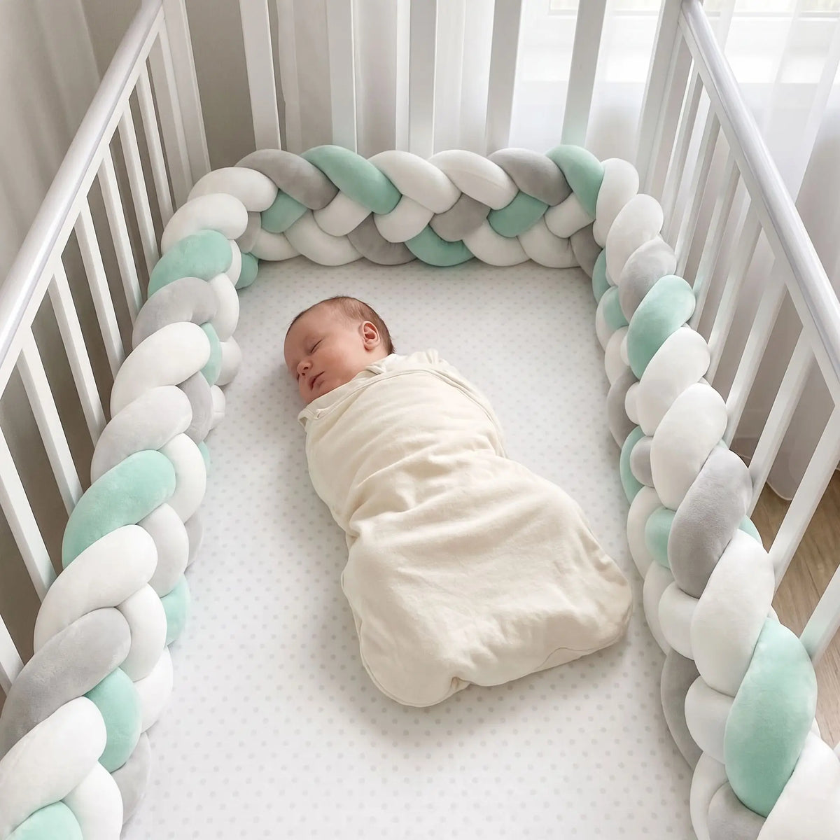Bébé qui dort en sécurité grâce au tour de lit tressé anti-coincement