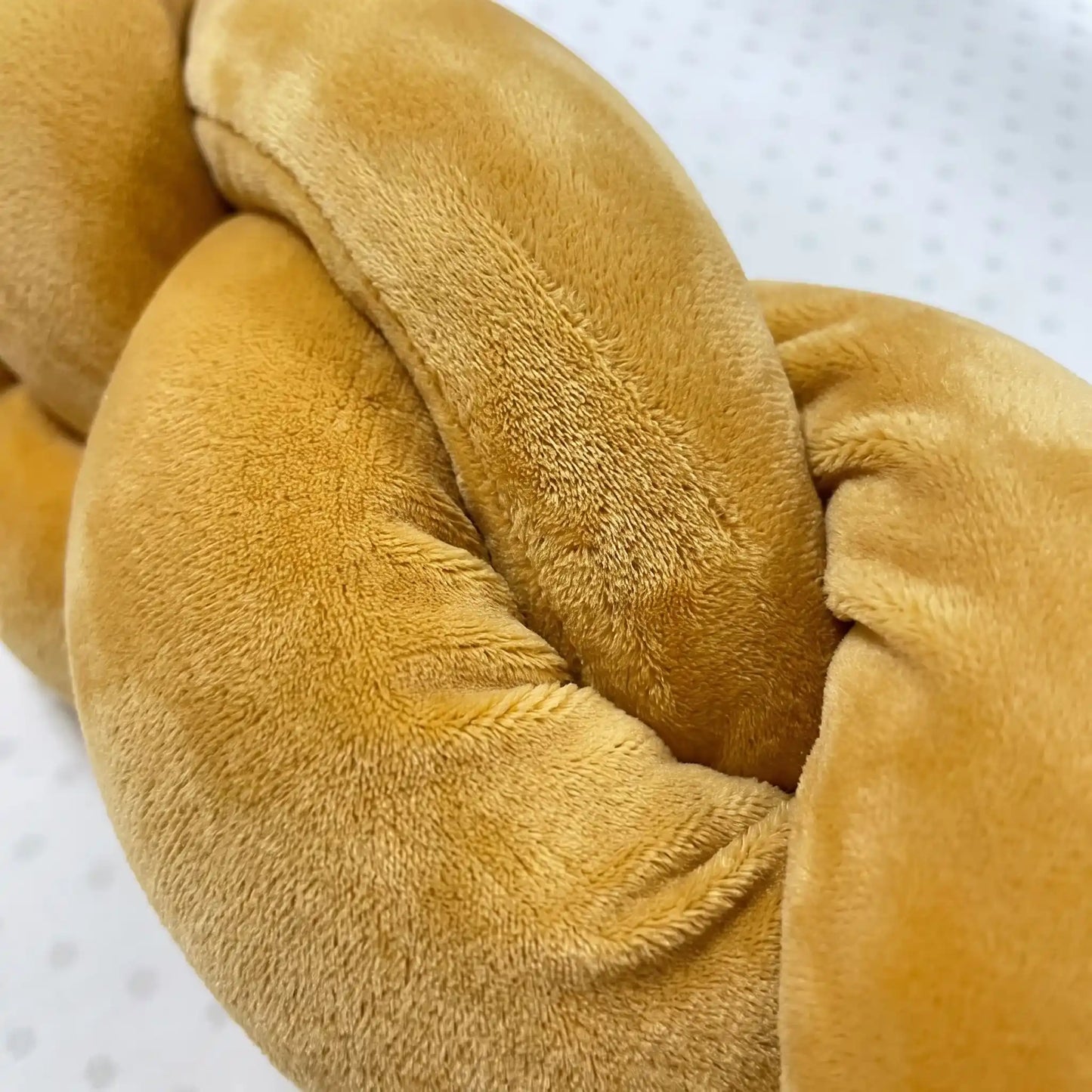 Détail de la tresse de lit bébé nouée à la main en feutre de coton hypoallergénique ocre