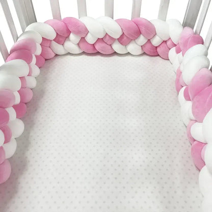 tresse de lit bébé pour fille de couleurs rose et blanc tout autour du lit à barreaux blanc de bébé