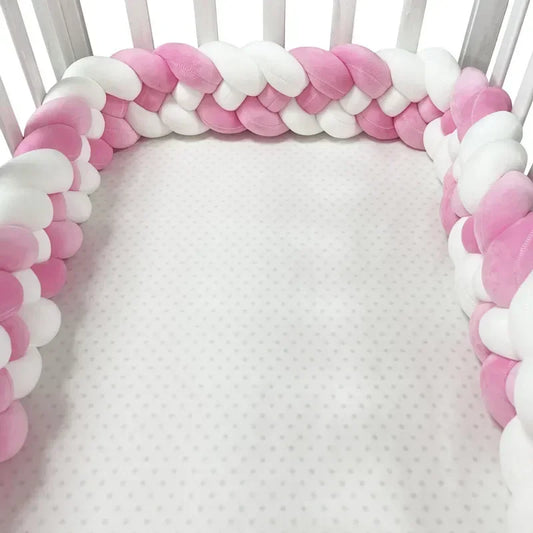 tresse de lit bébé pour fille de couleurs rose et blanc tout autour du lit à barreaux blanc de bébé