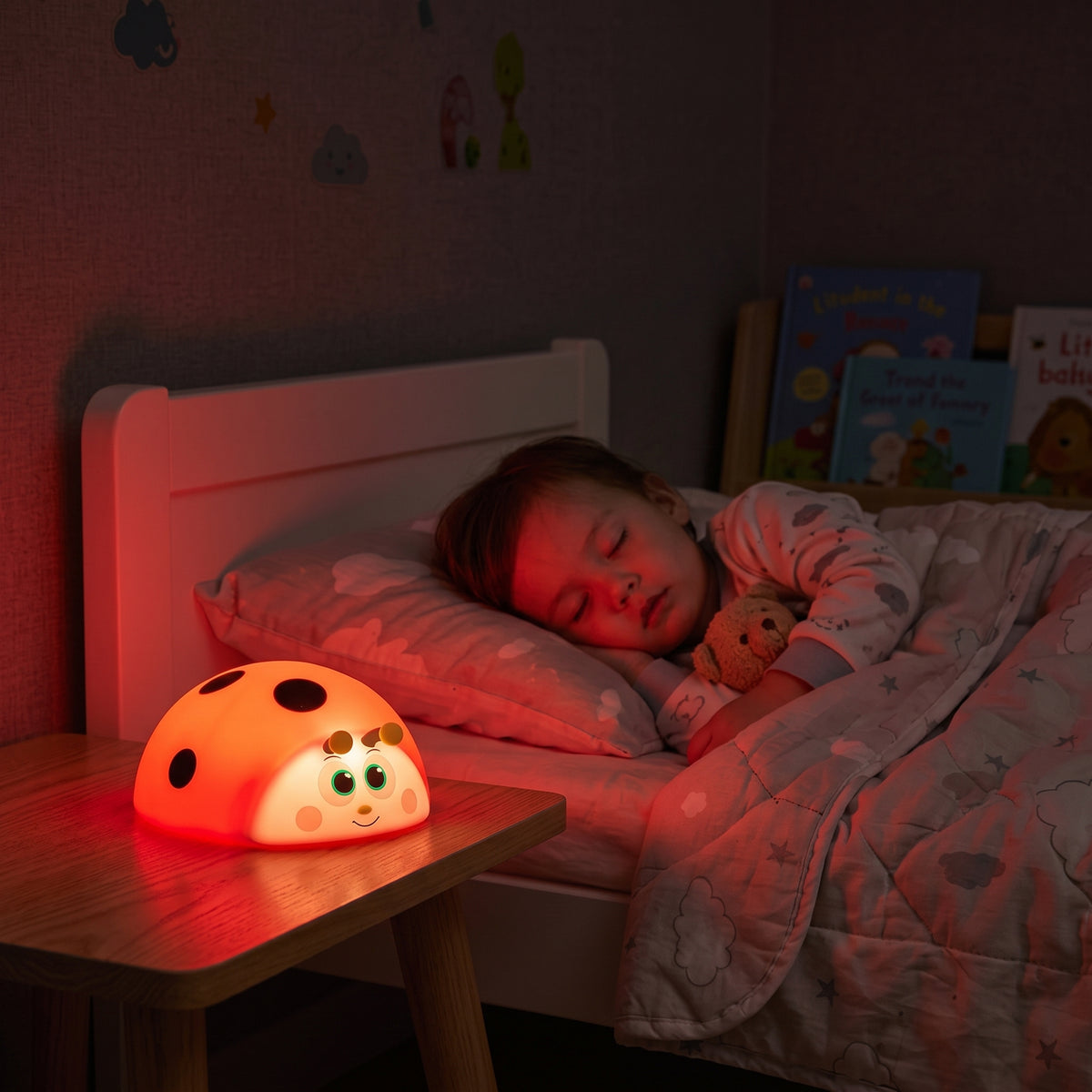 petite fille qui dort paisiblement avec sa veilleuse bébé coccinelle lumière rouge apaisante sans lumière bleue