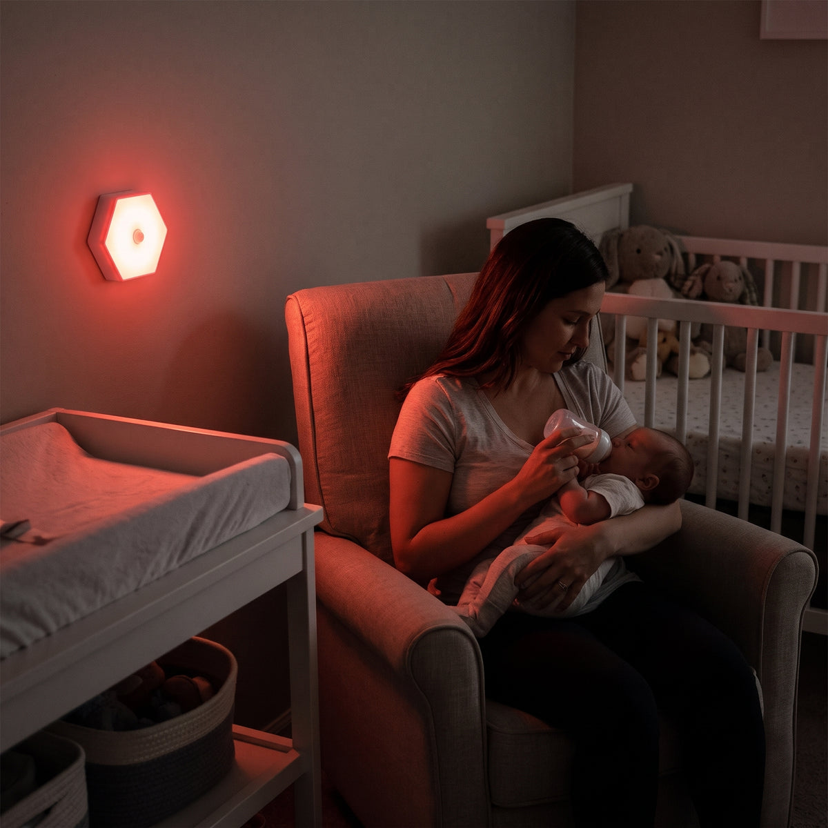 maman qui donne le biberon à son bébé dans l'obscurité éclairée par une veilleuse bébé lumière rouge sans lumière bleue détecteur de mouvement