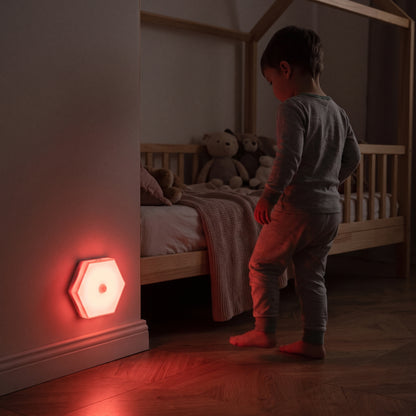 petit garçon sortant de son lit avec une veilleuse bébé lumière rouge détecteur de mouvement qui s'allume et éclaire dans l'obscurité