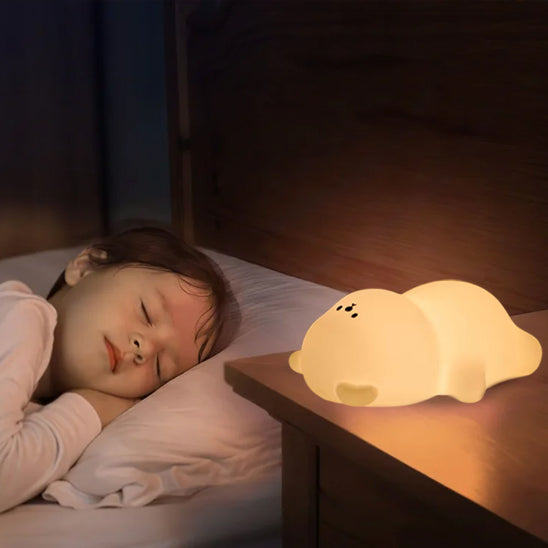 veilleuse ourson sur table avec enfant endormi